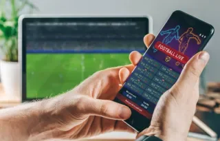 Person holding phone with sports data on it