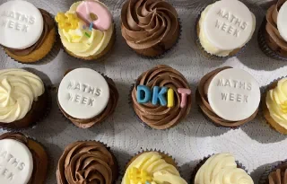 Assortment of decorated cupcakes for Maths Week, featuring chocolate and vanilla icing.
