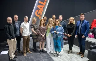 The crew of Reflection with the 2022 John Moore Film Award trophy alongside lecturing staff on the programme, Head of School Fergal McCaffrey and Head of Department, Adele Commins