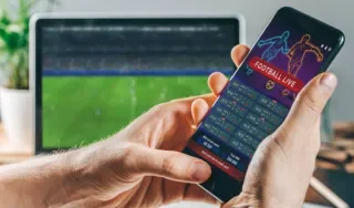 Person holding phone with sports data on it