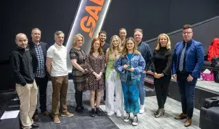 The crew of Reflection with the 2022 John Moore Film Award trophy alongside lecturing staff on the programme, Head of School Fergal McCaffrey and Head of Department, Adele Commins