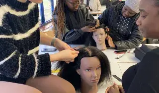 Students learning hair braiding techniques as part of Black History organised by DkIT's Students' Union